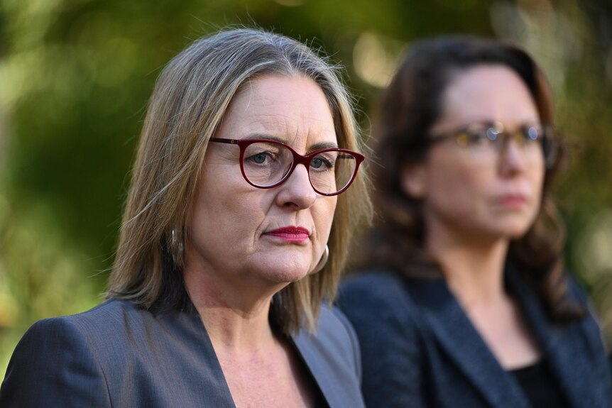 Jacinta Allan looks serious at an outdoor press conference.