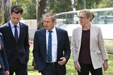 A group of politicians in suits walk together.