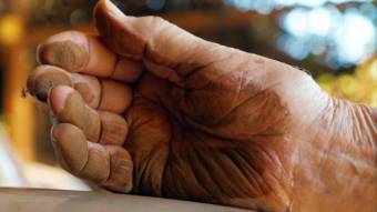 Dust covers a man's hand after he wiped it on a car.