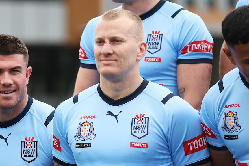 A man smiles during a rugby league team photo 