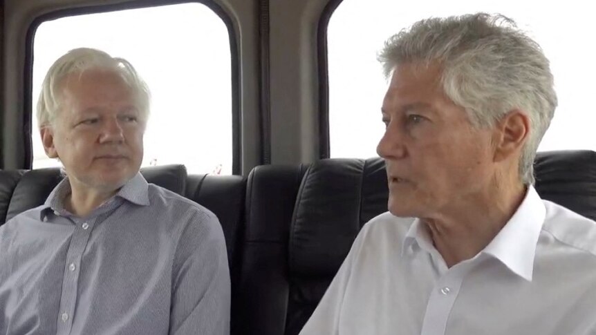 Three men sitting in the back of a car, talking