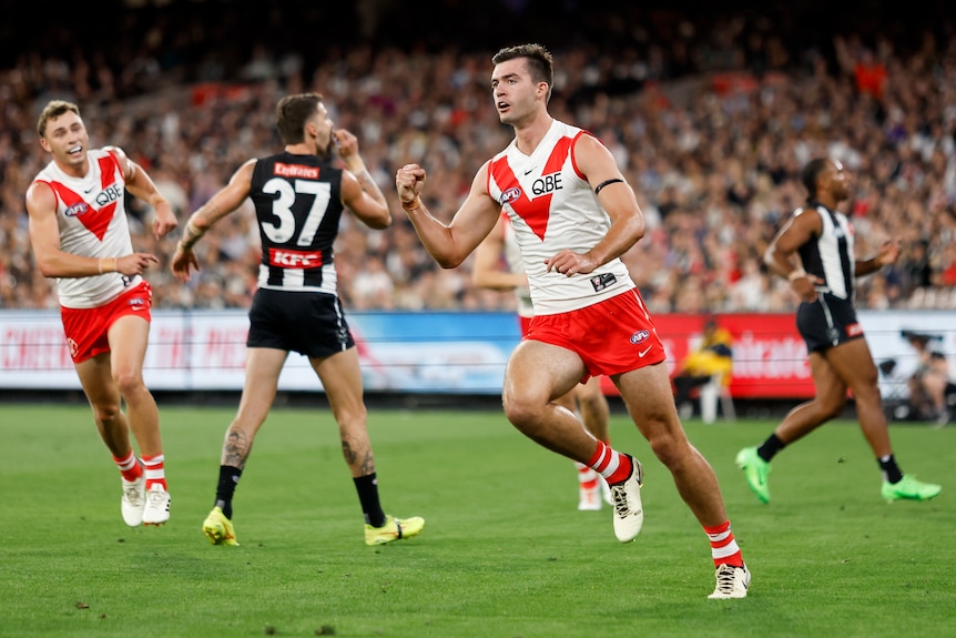 A Sydney Swans forward pumps his fist as he runs away after a goal.