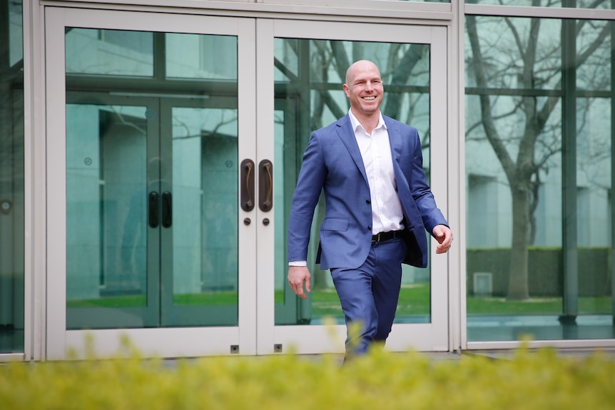 David Pocock walks in a courtyard inside Parliament House.