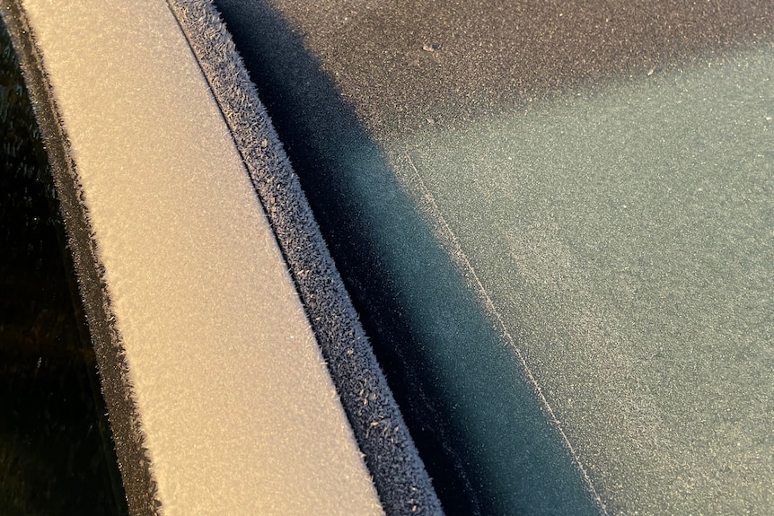 Icy particles across a white car's windscreen. 