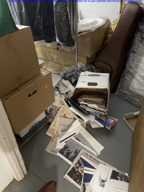 A box on the ground spills documents across the floor 