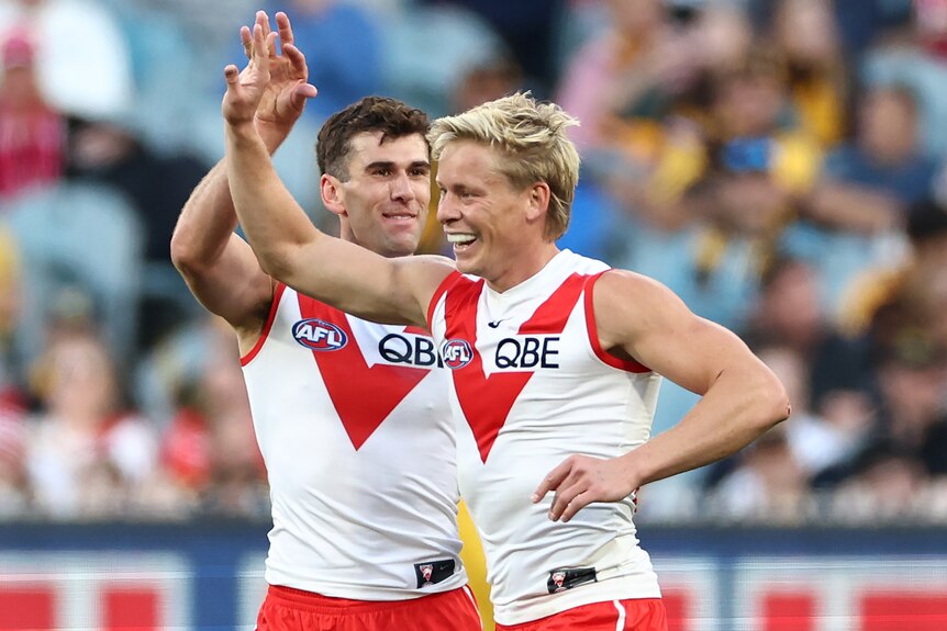 Isaac Heeney is congratulated after kicking a Sydney Swans AFL goal.