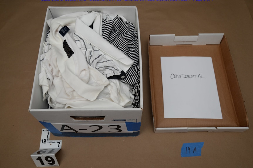 A box with the lid removed showing crumpled clothing 