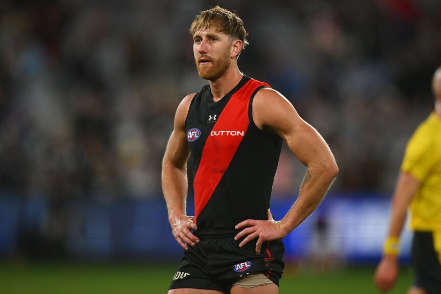 Dyson Heppell stands on the MCG after Essendon's AFL loss to Geelong.