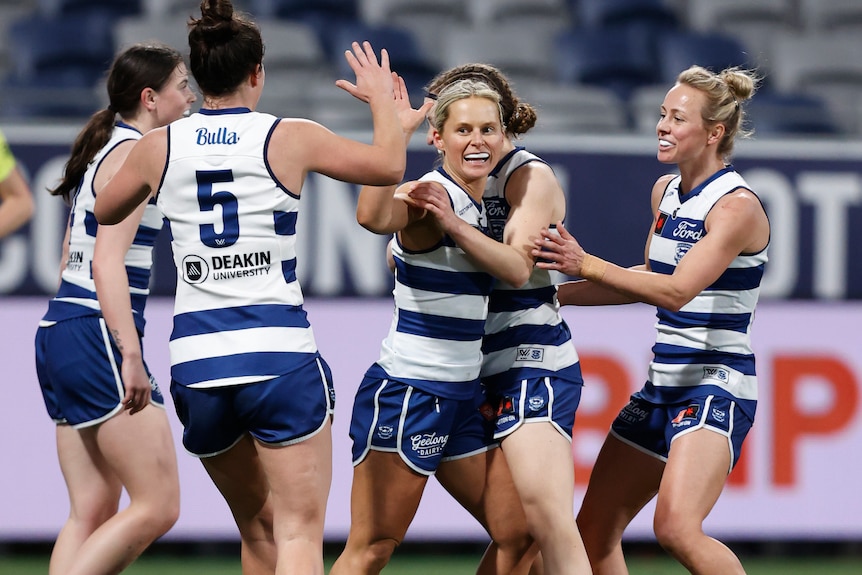 Kate Surman is congratulated by her Geelong teammates after kicking a goal in round one of AFLW 2023