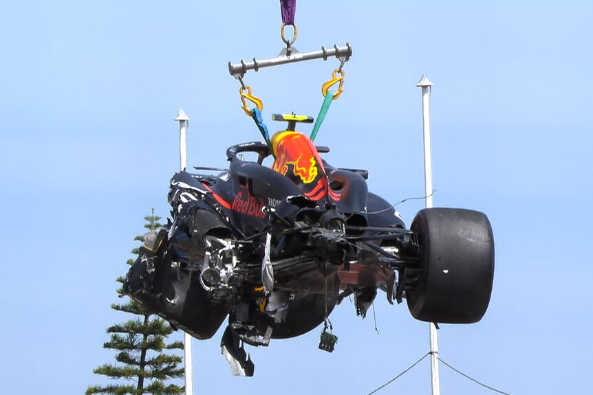 Wrecked F1 car lifted in the air after a crash