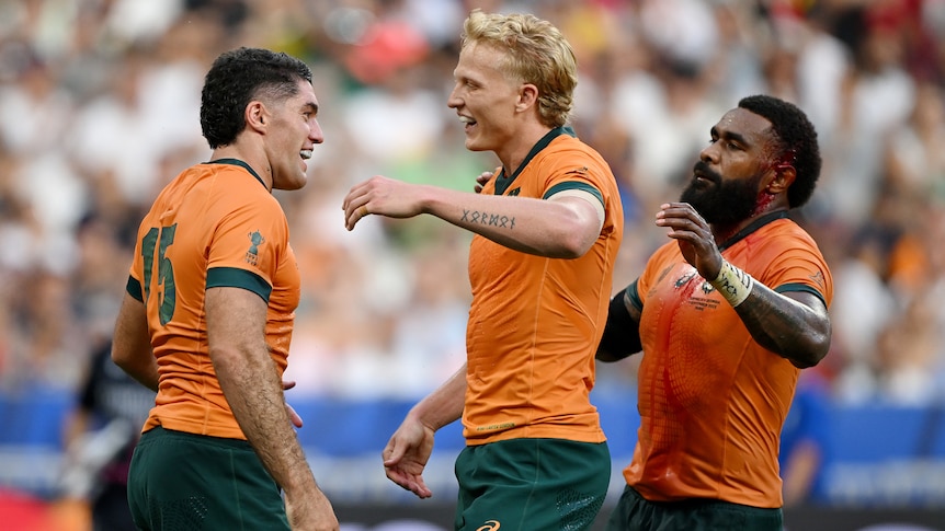 Three Wallabies players celebrate a try against Georgia.