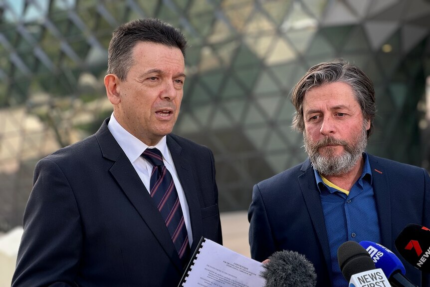 Two men with stern expressions fron the media