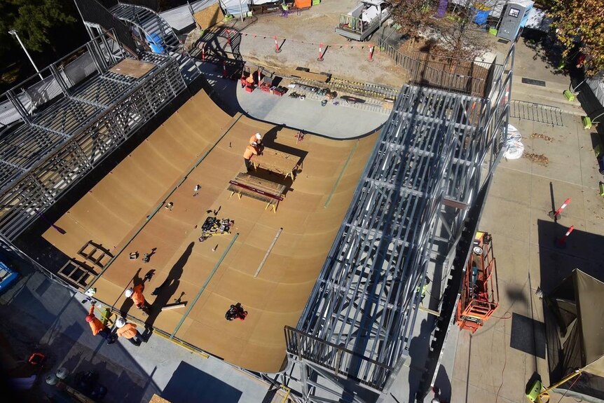 Construction workers building the frame of a skateboard ramp. 