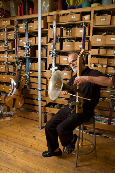 Trimpin playing a stringed instrument of his own design.