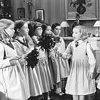 Madeline (Hatty Jones, second from right) and faithful helper Aggie (Clare Thomas, far right) instruct their schoolmates in the fine art of housecleaning.