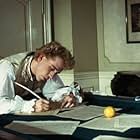 Mozart (TOM HULCE) composes music over a billiard table