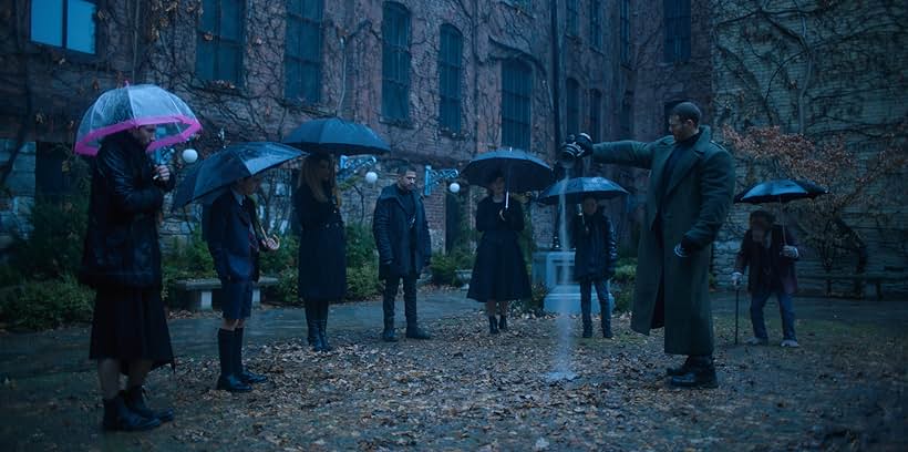 Adam Godley, Elliot Page, Robert Sheehan, Tom Hopper, David Castañeda, Aidan Gallagher, Jordan Claire Robbins, and Emmy Raver-Lampman in The Umbrella Academy (2019)