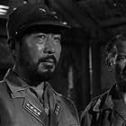 Dale Ishimoto and John Mills in King Rat (1965)