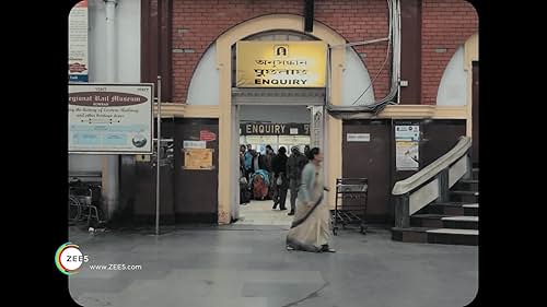 Amidst the daily din of the local trains in Calcutta, a lonely working woman in her late fifties finds herself falling in love with the voice of the railway announcer.