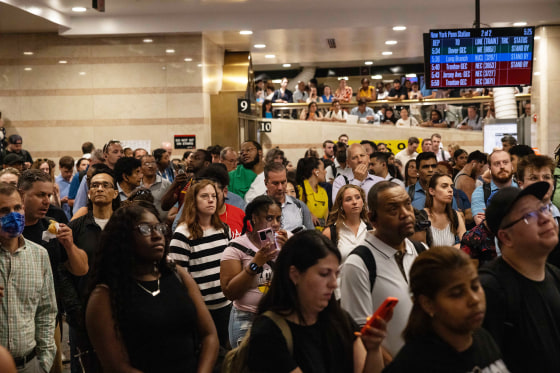 Commuters looking at the phones and boards for gates