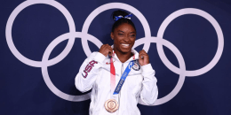 Ariake Gymnastics Centre, Tokyo, Japan - August 3, 2021. Bronze medallist Simone Biles of the United States poses in front of the Olympic rings. REUTERS/Mike Blake