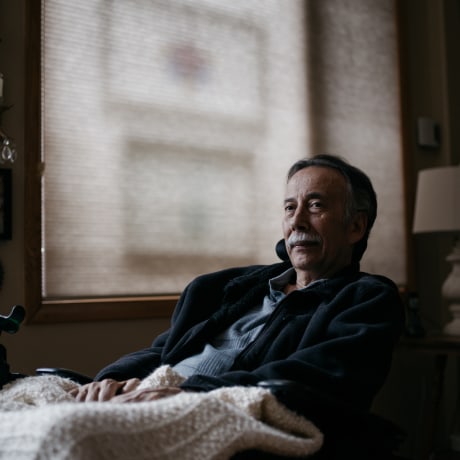 George Gallegos sits at his home.