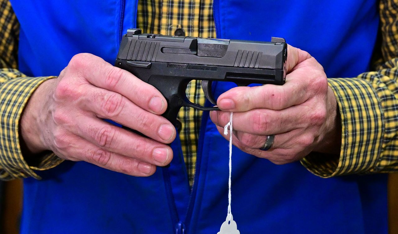 Patrick Jones, Shasta County supervisor and gun shop owner, displays a Sig Sauer Pistol on February 24 in Redding in Northern Califonia's Shasta County.