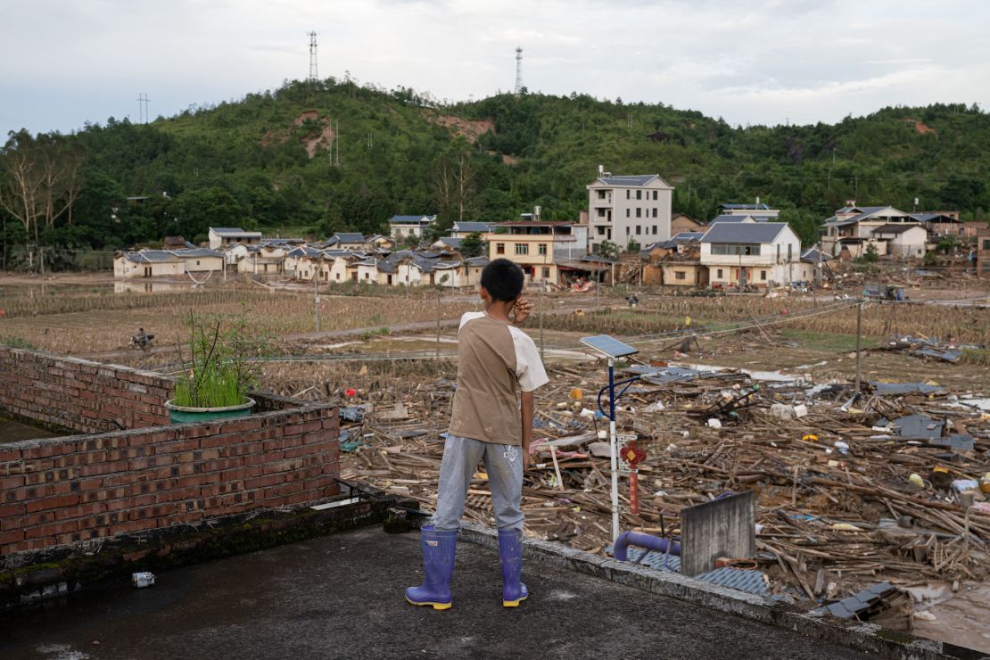 A child looks at flooded fields following heavy rainfall in Meizhou, Guangdong province on June 23, 2024.