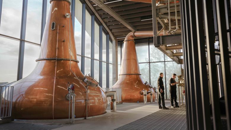 DISTILLERY WORKERS TAKE THE CUT AT THE SPIRIT SAFE AT PORT ELLEN DISTILLERY, COLLECTING WHISKY FROM THE STILLS AFTER 40 YEARS OF CLOSURE