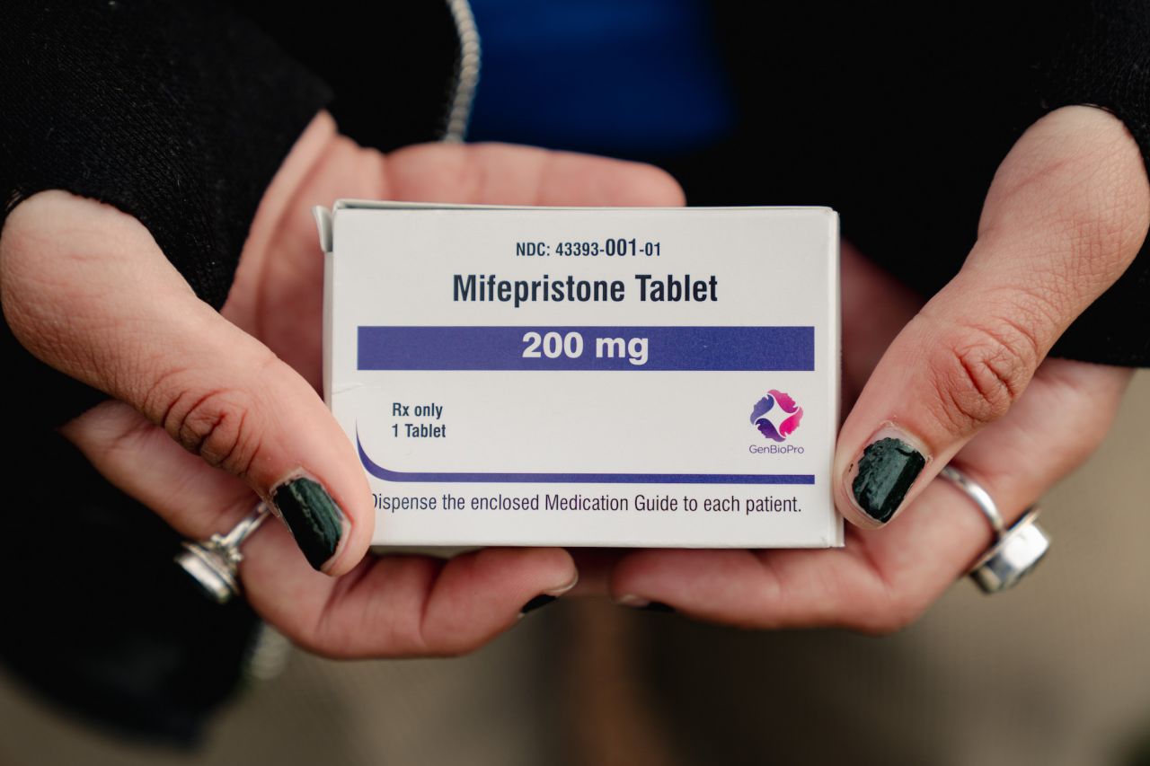 An abortion rights advocate shows a box of mifepristone outside the Supreme Court on March 26.