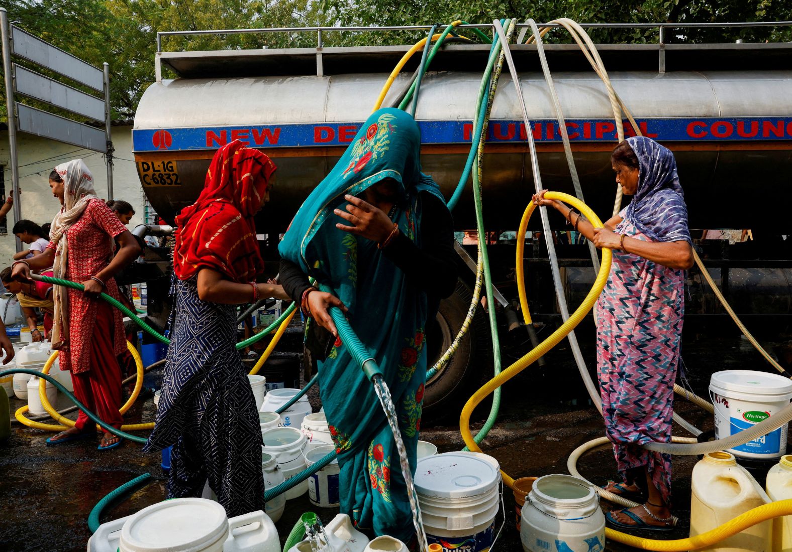 People visit a water tanker to fill their containers with drinking water during a hot day in New Delhi on Monday, June 24. <a href="https://www.cnn.com/2024/06/21/india/india-delhi-nighttime-heatwave-climate-intl-hnk/index.html">Northern India has endured a scorching summer</a>, with one part of Delhi reaching 49.9 degrees Celsius (121.8 degrees Fahrenheit) in late May — the capital’s highest temperature on record.