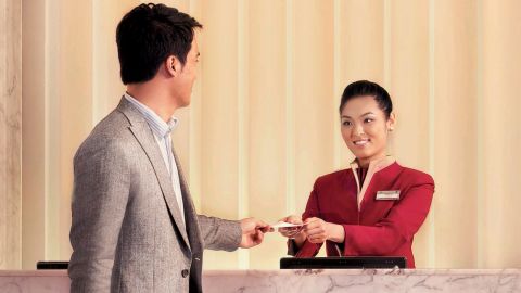 Cathay Pacific Hong Kong Lounge. Airline crew greeting customer