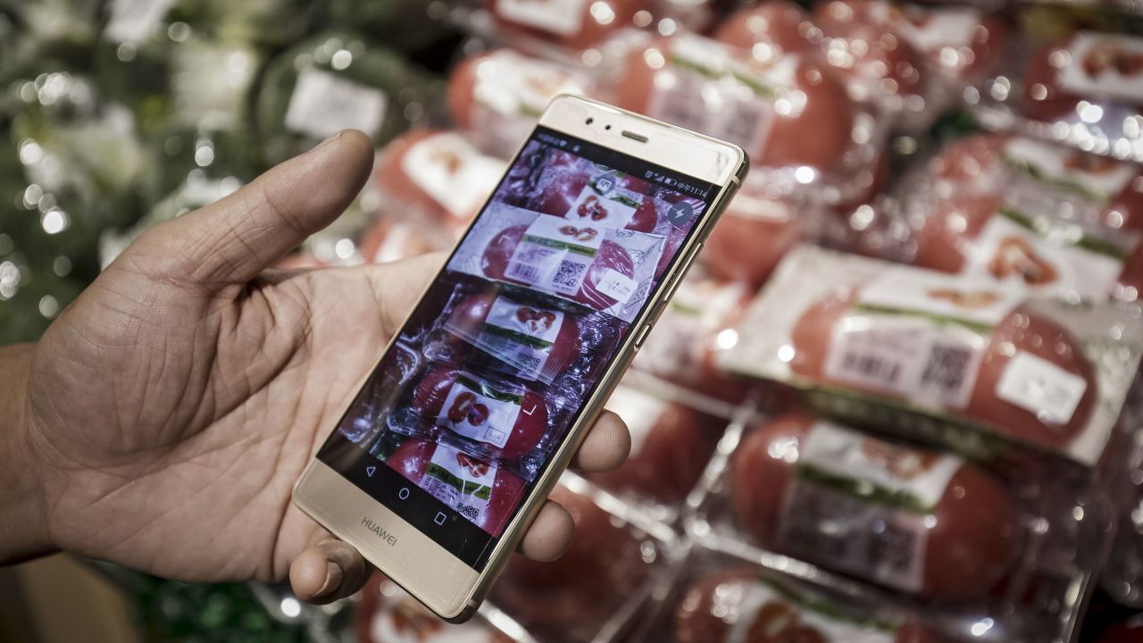 A customer displays the Hema application on a Huawei Technologies Co. smartphone while shopping at an Alibaba Group Holding Ltd. Hema Store in Shanghai, China, on Tuesday, Sept. 12, 2017. Hema stores are one-stop shops where users can pay with their mobile app, get recommendations by scanning product bar codes, and have seafood cooked on the spot, and also serving as last-mile delivery fulfillment centers, where goods get to buyers within 30 minutes. Photographer: Qilai Shen/Bloomberg via Getty Images