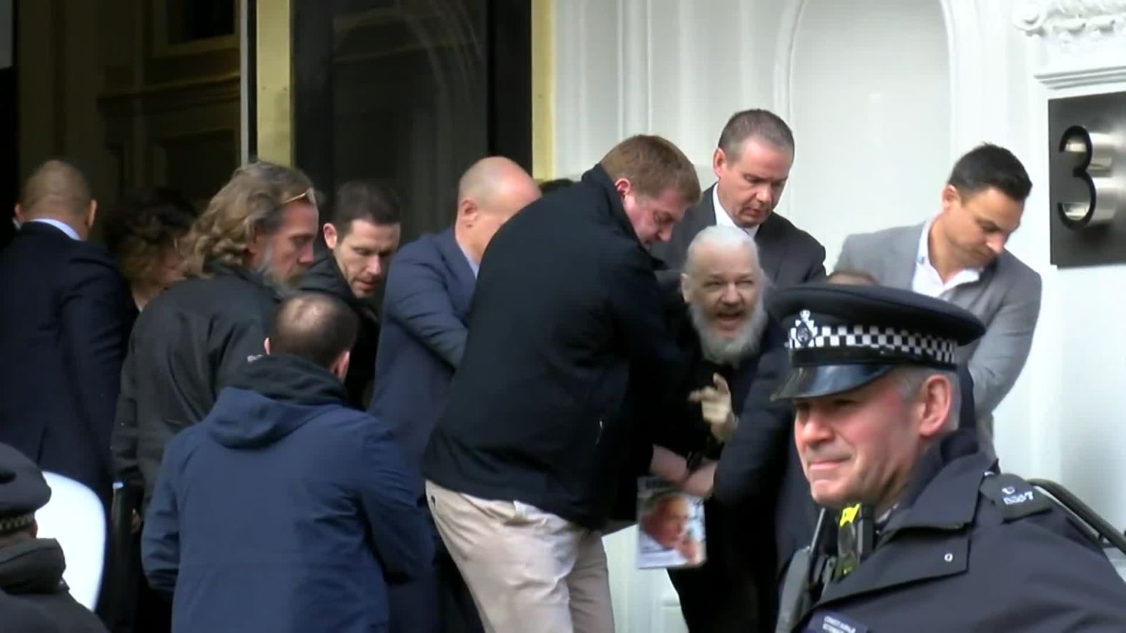 A screen grab from video footage shows the dramatic moment when Assange was <a href="https://edition.cnn.com/2019/04/11/uk/julian-assange-arrested-gbr-intl/index.html" target="_blank">hauled out of the Ecuadorian Embassy by police</a> in April 2019. Assange was arrested for "failing to surrender to the court" over a warrant issued in 2012. Officers made the initial move to detain Arrange after Ecuador withdrew his asylum and invited authorities into the embassy, citing his bad behavior.