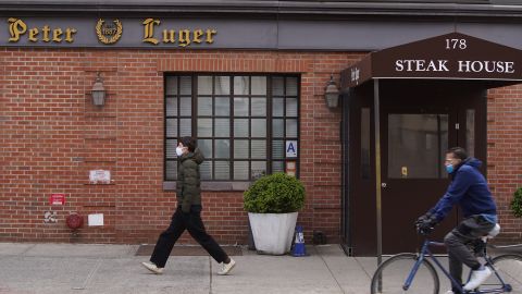 NEW YORK, NEW YORK - MAY 09: People walk past Peter Luger steak house in the Williamsburg neighborhood of Brooklyn during the coronavirus pandemic on May 9, 2020 in New York City. COVID-19 has spread to most countries around the world, claiming over 279,000 lives with infections of over 4 million people. (Photo by Rob Kim/Getty Images)