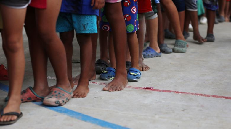 Venezuelan migrant children line up inside a coliseum where a temporary camp has been set up, after fleeing their country due to military operations, according to the Colombian migration agency, in Arauquita, Colombia March 26, 2021. REUTERS/Luisa Gonzalez     TPX IMAGES OF THE DAY