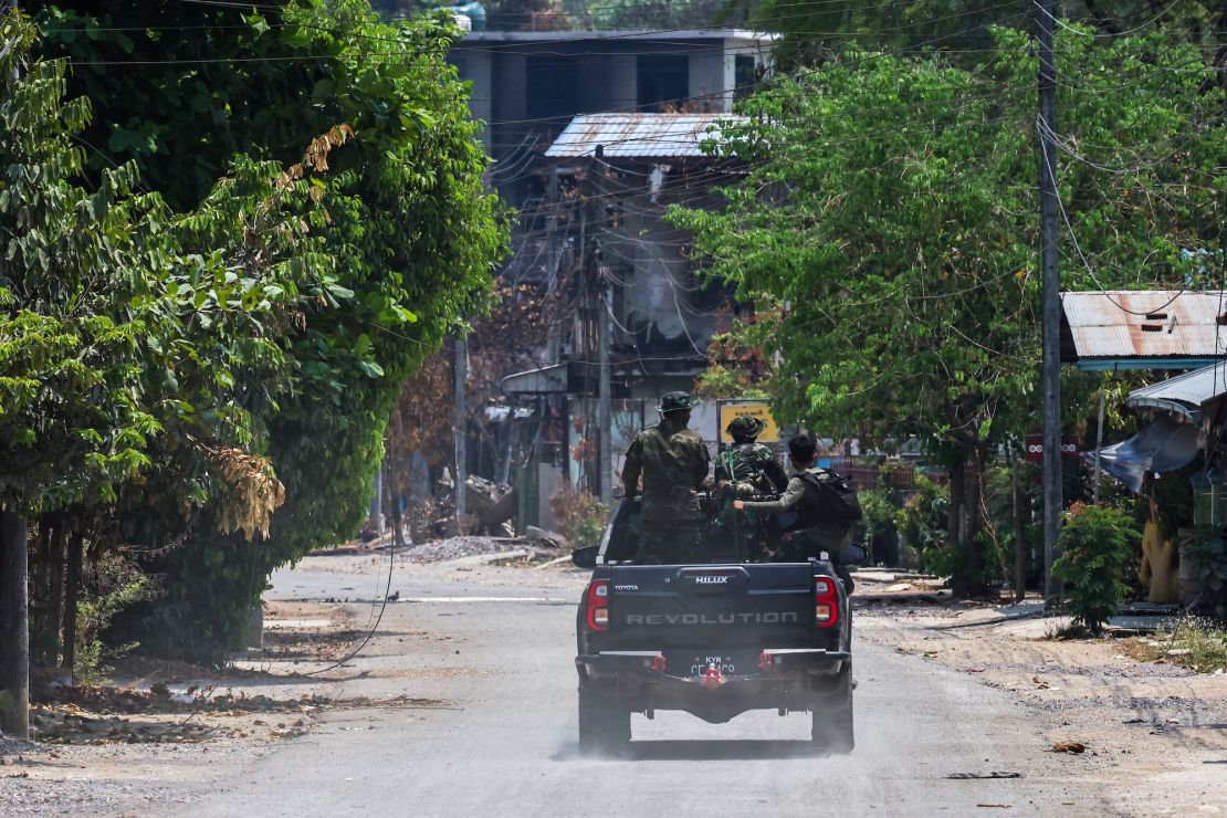 Soldiers from the Karen National Liberation Army (KNLA) patrol on a vehicle, next to an area destroyed by a Myanmar military airstrike in Myawaddy, a Thailand-Myanmar border town in Myanmar, April 15, 2024.