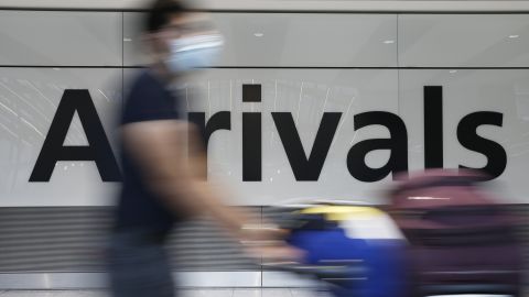 LONDON, ENGLAND - AUGUST 07: A traveler exits through the International Arrivals gate at Heathrow Airport on August 7, 2021 in London, England. As of 04:00 tomorrow, the UK again shuffles its "traffic light" system dictating quarantine requirements for arriving travelers. Most significantly, France moves from "amber-plus" to "amber," meaning that fully vaccinated travelers no longer need to quarantine. Meanwhile, Mexico moves to the red list, forcing arriving travelers to quarantine at their own cost in government-designated hotels. (Photo by Hollie Adams/Getty Images)