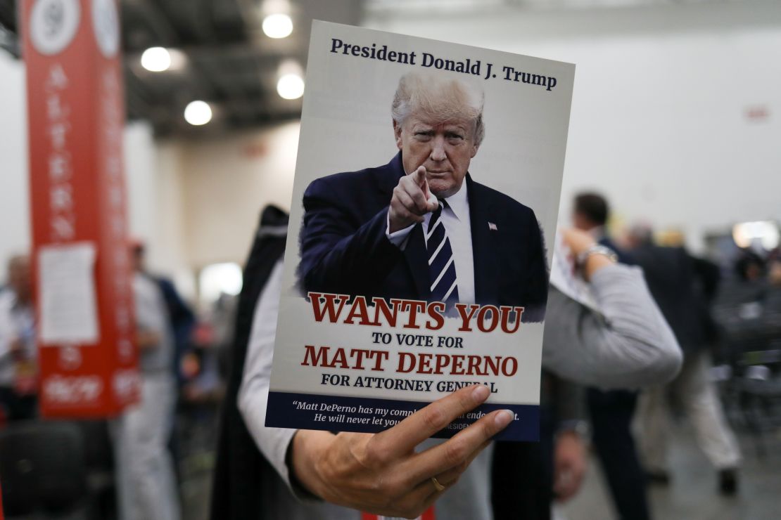 An attendee holds a sign in support of Matthew DePerno, the Republican nominee for Michigan attorney general, at a GOP convention in Grand Rapids, Michigan, on April 23, 2022.  