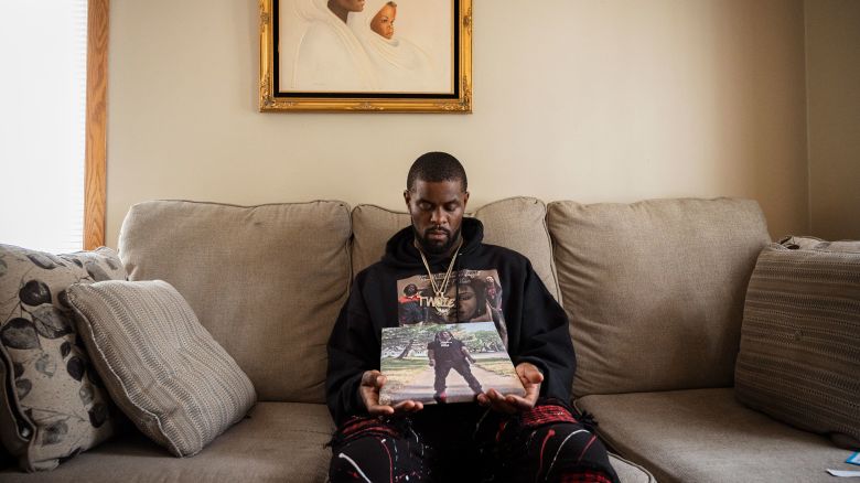 Telly Blair's brother holding a photo of him in their mother's home in North Minneapolis, MN.