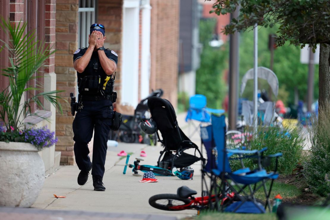 FILE - A Lake Forest, Ill., police officer walks down Central Ave in Highland Park, Ill., on Monday, July 4, 2022, after a shooter fired on the Chicago northern suburb's Fourth of July parade. Chicago is one of the nation's gun violence hotspots and a seemingly ideal place to employ Illinois' "red flag" law that allows police to step in and take firearms away from people who threaten to kill. But amid more than 8,500 shootings resulting in 1,800 deaths since 2020, the law was used there just four times. (Brian Cassella/Chicago Tribune via AP, File)