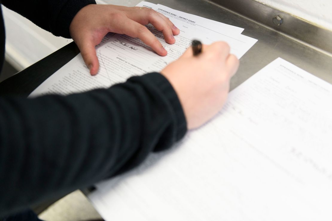 Tanner DeLapp, of The Bail Project, fills out bail forms for three clients on March 9 in Tulsa, Oklahoma.