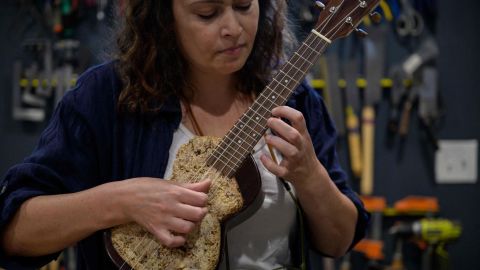 French luthier Rachel Rosenkrantz plays a ukulele made using mycelium in her studio on June 21, 2023, in Providence, Rhode Island. Leave mushroom spores in a mold for a couple weeks and they'll bloom into a puffy material akin to brie, says Rosenkrantz, a sustainability-minded guitar-maker innovating with bio-materials. Once her mycelium, the root-like structure of fungus that produces mushrooms, mimics the rind of a soft-ripened cheese Rosenkrantz dehydrates it into a lightweight, biodegradable building material -- in this case, a guitar-body. (Photo by ANGELA WEISS / AFP) (Photo by ANGELA WEISS/AFP via Getty Images)