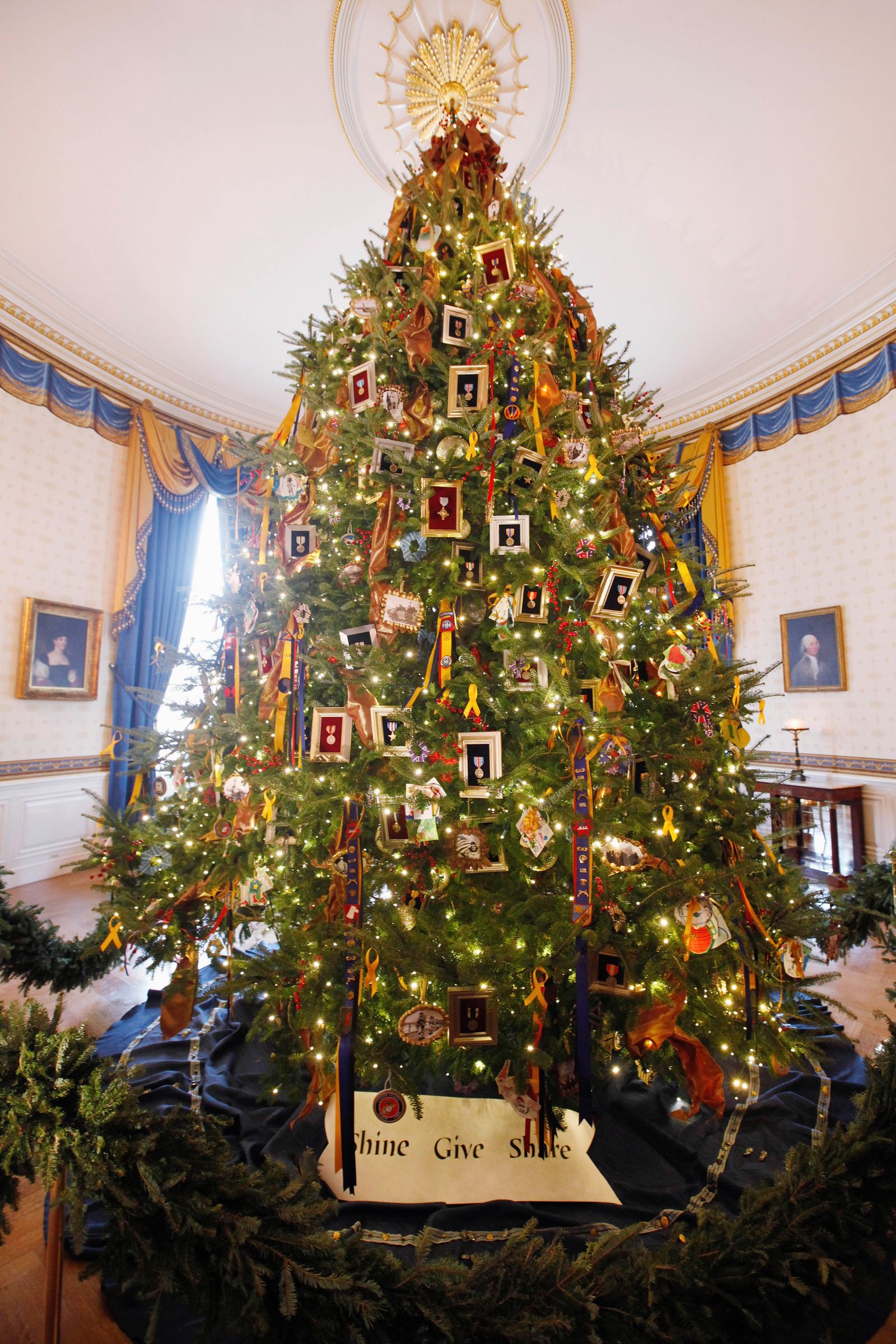 The White House Christmas Tree is seen during a press preview, Wednesday Nov. 30, 2011, in the Blue Room of the White House in Washington. The tree, whose theme is "Shine, Give, Share" honors military families.  (AP Photo/Charles Dharapak)