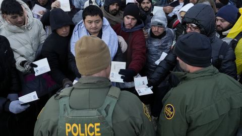 Border Patrol agents ask asylum-seeking migrants to line up in a makeshift, mountainous campsite after the group crossed the border with Mexico, Friday, Feb. 2, 2024, near Jacumba Hot Springs, Calif. (AP Photo/Gregory Bull)