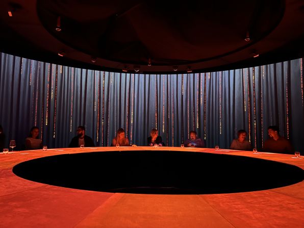 In a round room, at a 20-seat circular table, guests prepare for the show. The walls are projector screens, with more than 20 projectors and a multitude of sensors on the table.