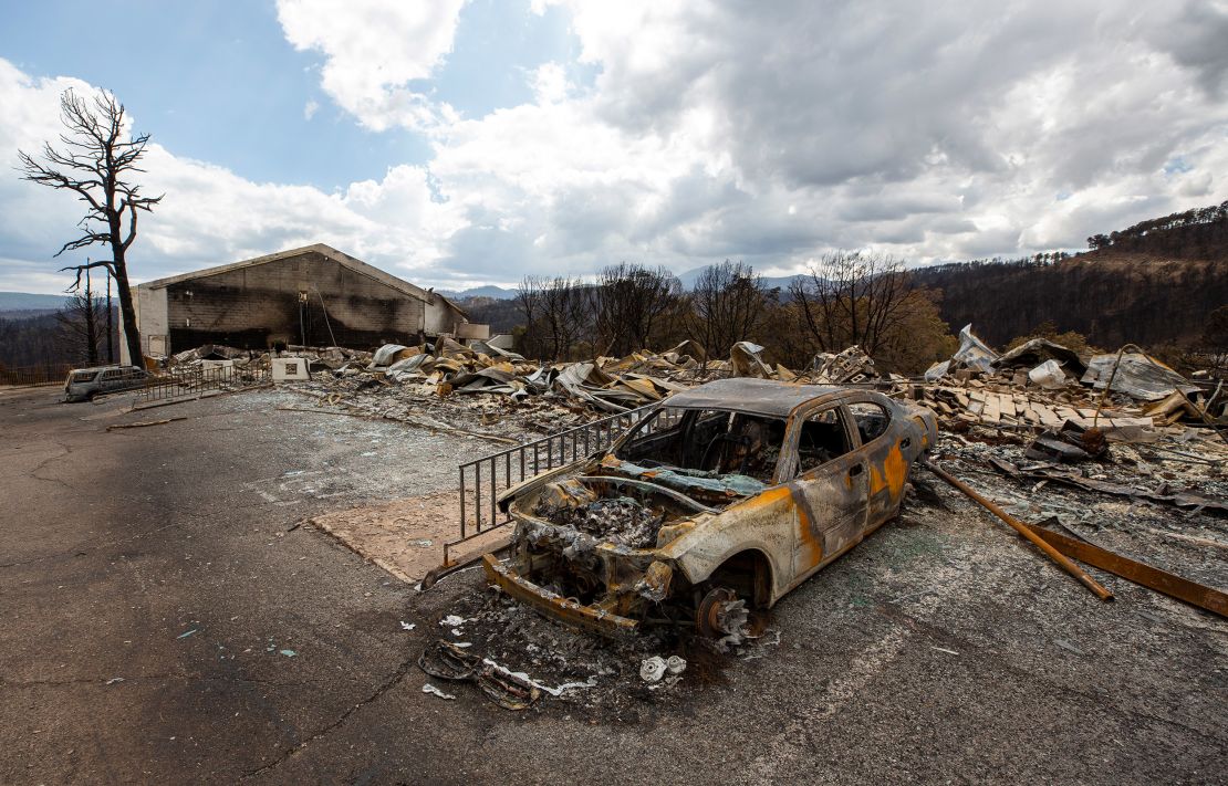 A charred car and the remains of the Swiss Chalet Hotel are pictured after being destroyed by the South Fork Fire in the mountain village of Ruidoso, New Mexico, on Saturday.