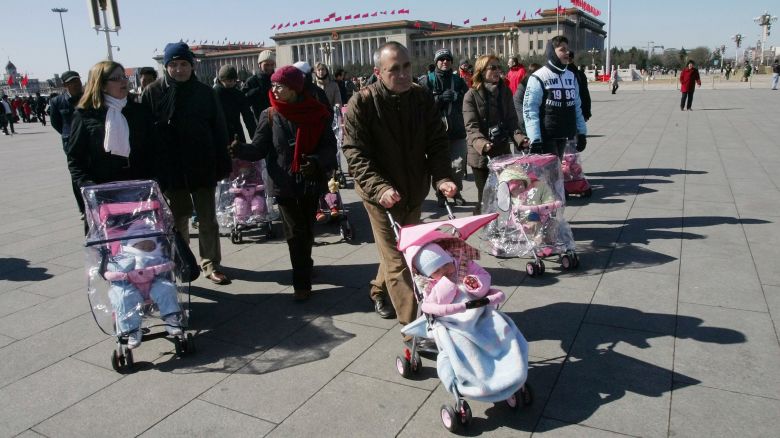 Spanish couples take their newly adopted Chinese children for a walk in Beijing's Tiananmen Square, on March 7, 2007.