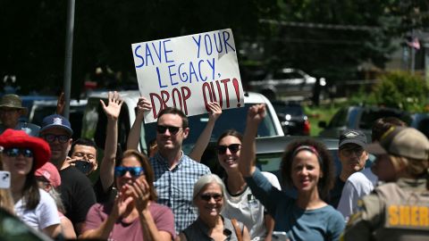 A person holds up a sign encouraging President Joe Biden to drop out of the 2024 presidential race as Biden's motorcade arrives at a campaign rally at Sherman Middle School in Madison, Wisconsin, on July 5.