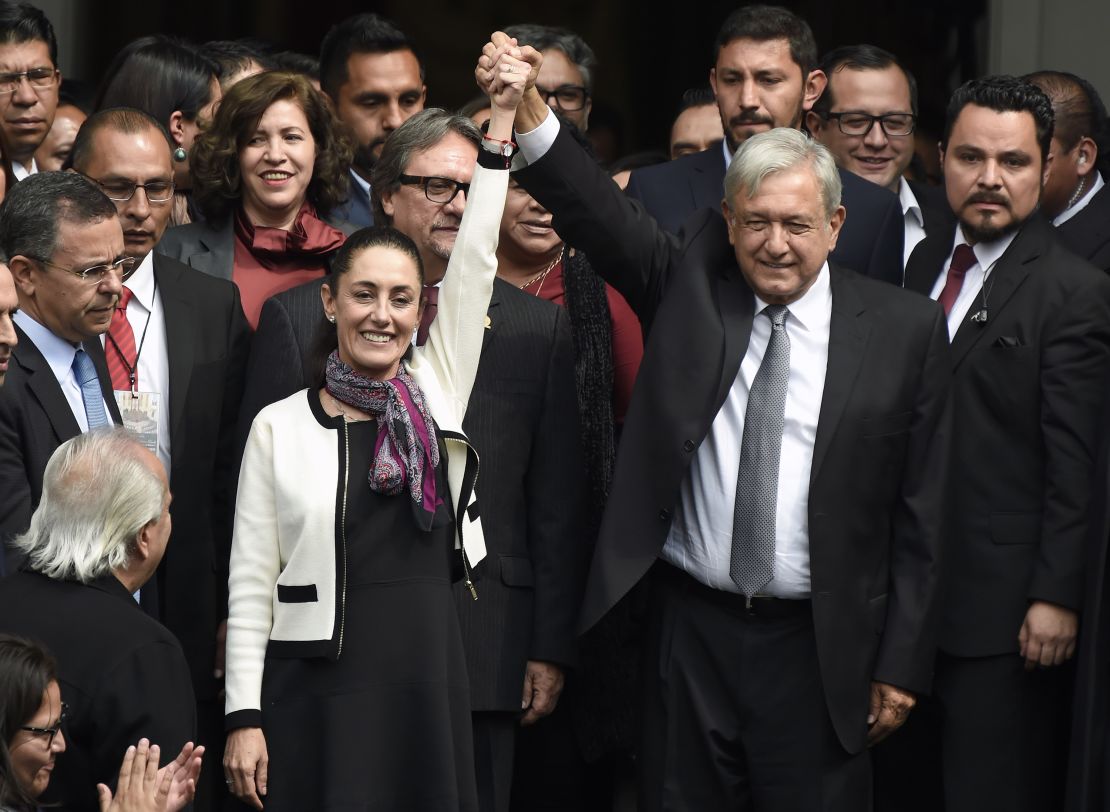 Mexican President Andres Manuel Lopez Obrador raises Sheinbaum's hand after she was sworn in as Mexico City's mayor on December 5, 2018.